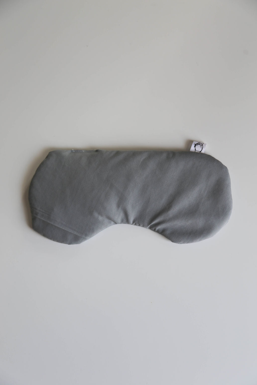Natural therapy eye mask shown, highlighting soft fabric and compact size for targeted pain relief.