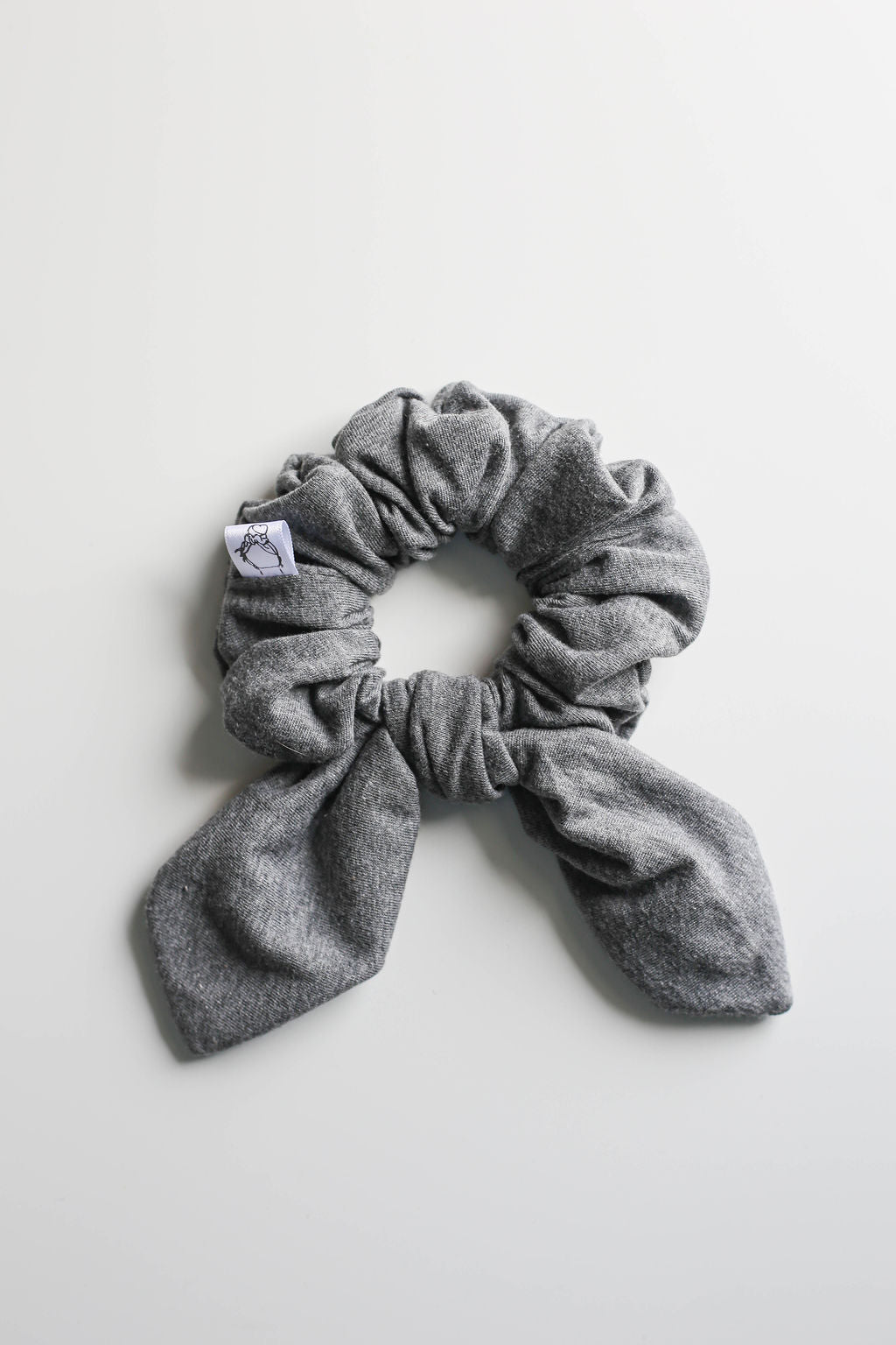 Gray scrunchie with a bow on a light gray background