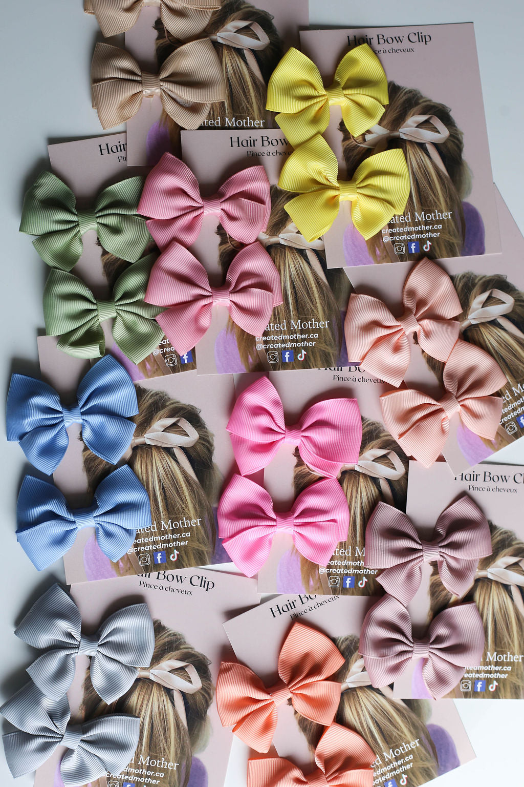 Flat lay of assorted ribbon bows with branded backing cards ready for boutique display.