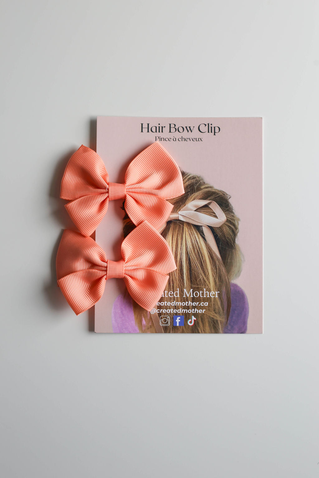 Hair clip with brightl ribbon bow shown on elegant packaging for gifting or retail shelves.