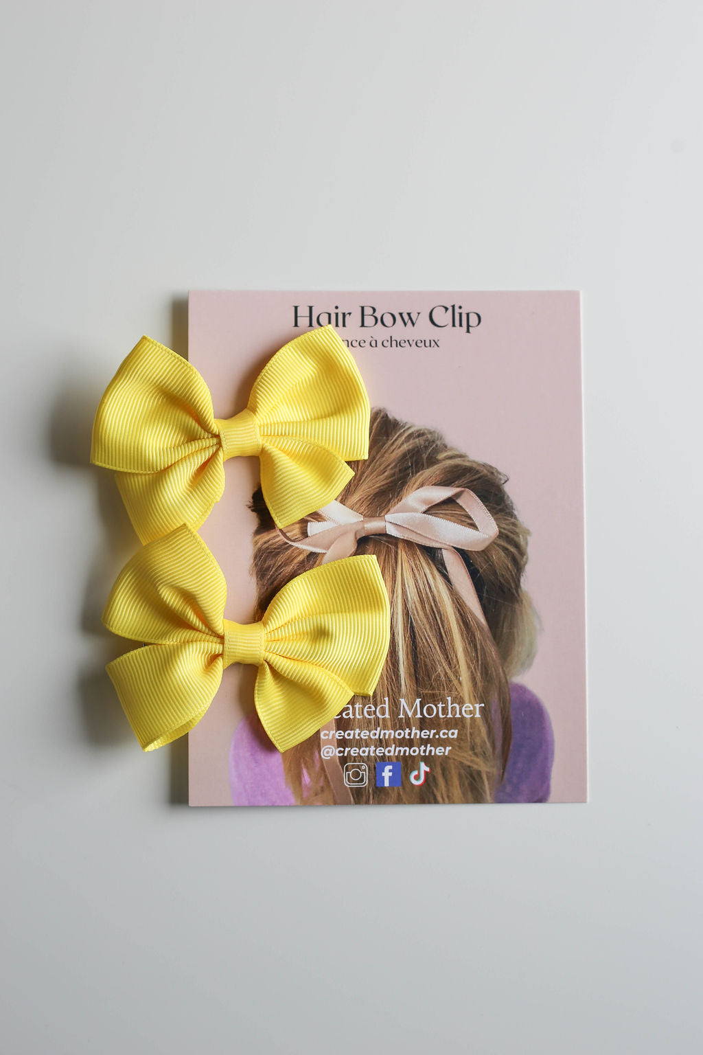 Mini bow in bright yellow with polished finish, perfect for spring and summer styling.