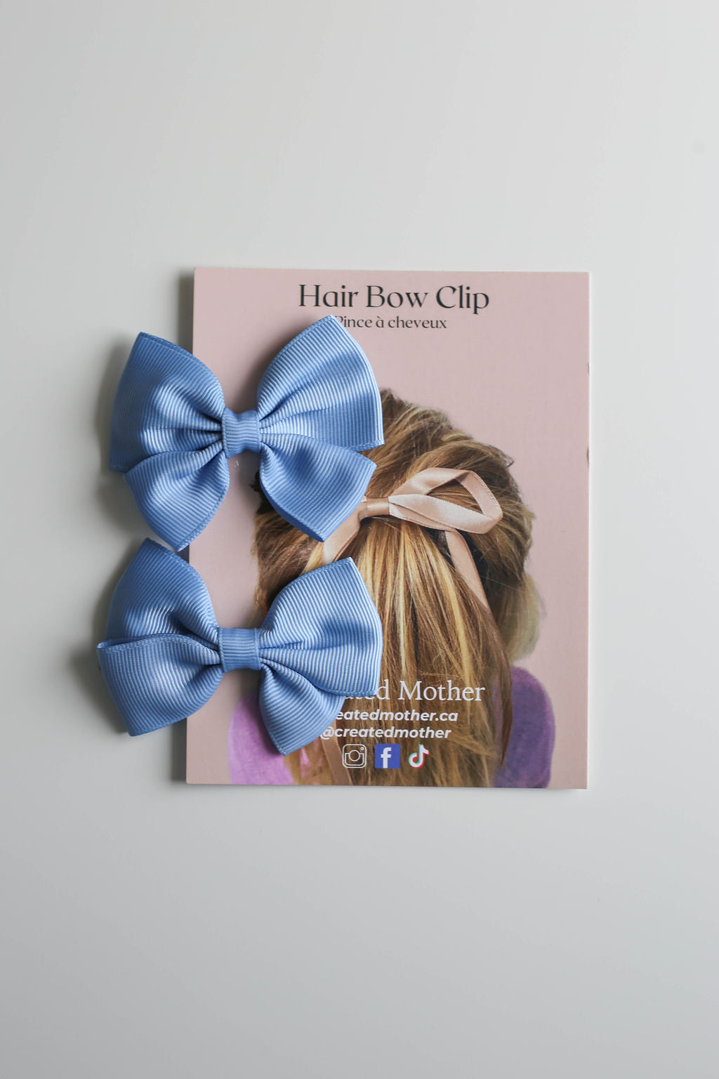 Classic blue ribbon bow with secure metal clip, ideal for toddlers to adults.