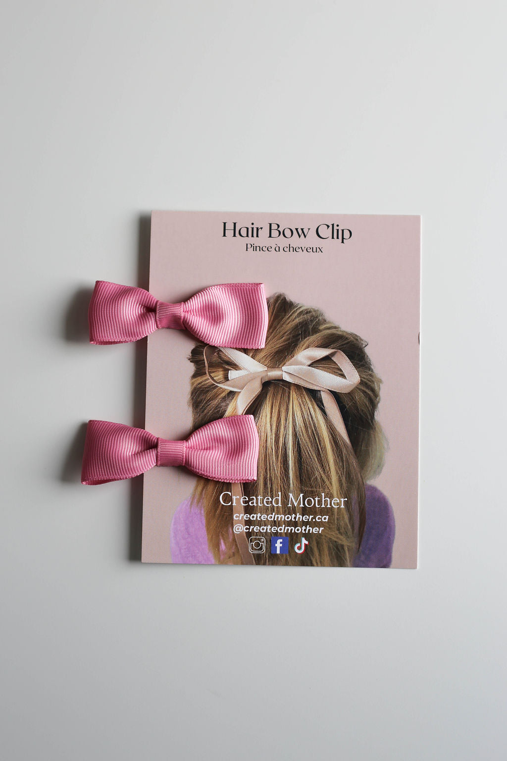Matching bow clips in soft pink, perfect for casual styling or special occasions.