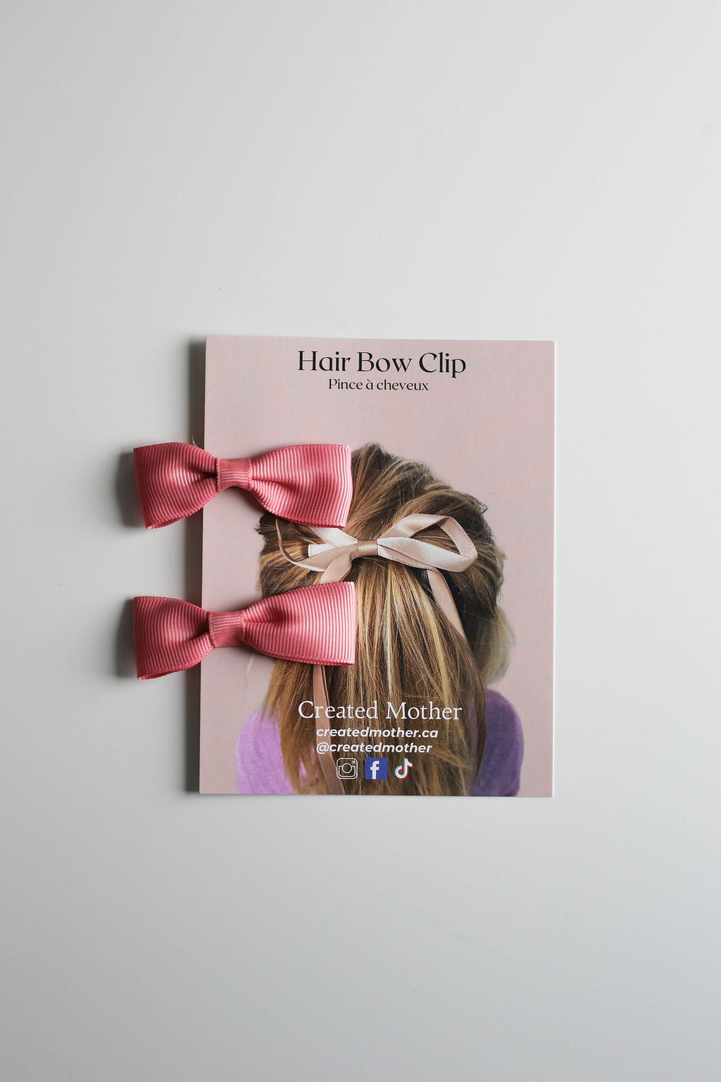 A pair of coral pink matching bows, perfect for adding the finish touch to pigtails or braids