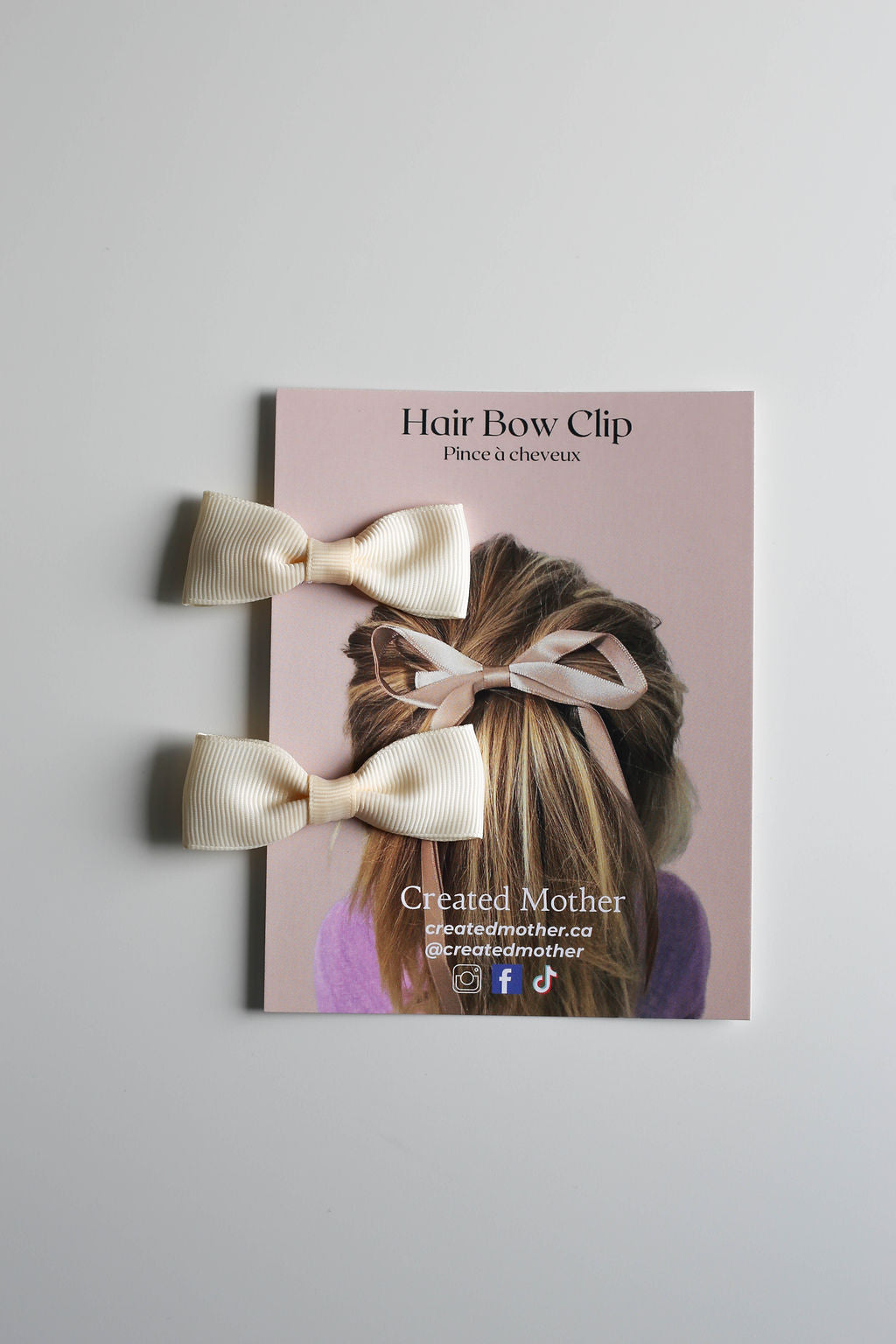 Handmade small bow clips in neutral cream, secured to a 4.25” x 5.5” display card.