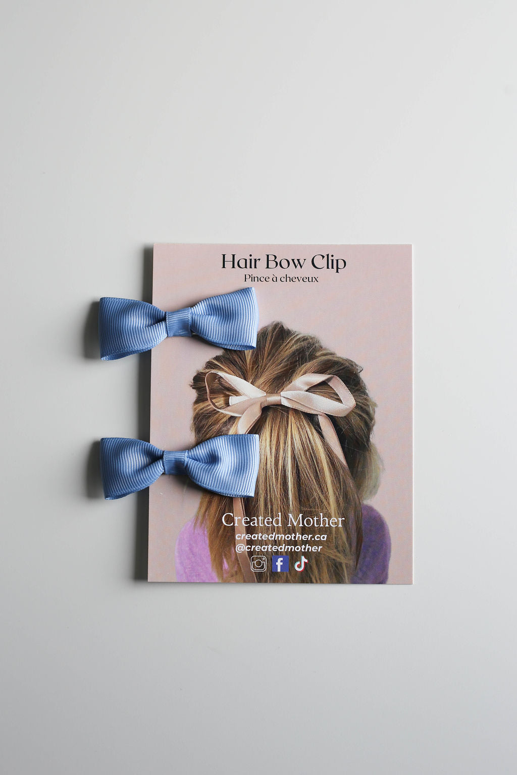 Small handmade bow clip set in classic blue, ideal for gifting or boutique display.