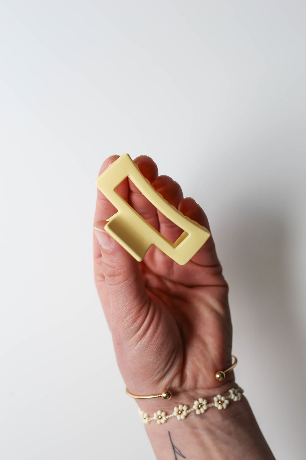 Small sunny yellow claw clip with matte texture and modern styling