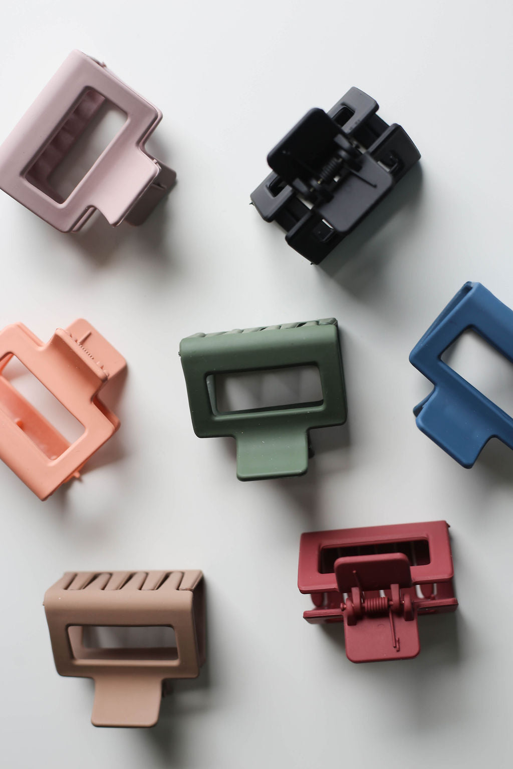 Flat lay of modern square clips in assorted neutral and pastel tones, perfect for everyday wear.