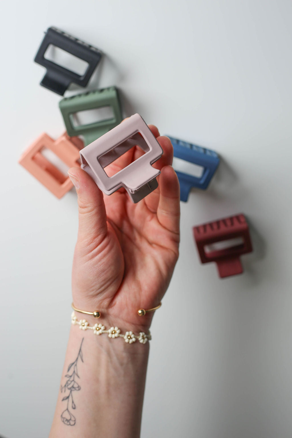 Single small square hair clip securing a neat half-up hairstyle on medium-length hair.