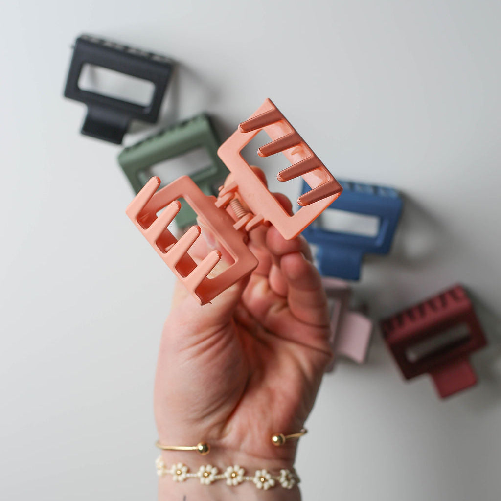 colorful 2” square claw clips displayed on a neutral background, showcasing assorted styles.