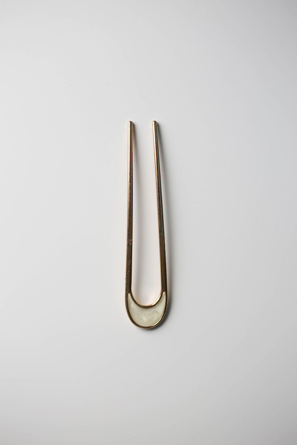 Gold vintage-style hair pin with smooth opal-like enamel design.