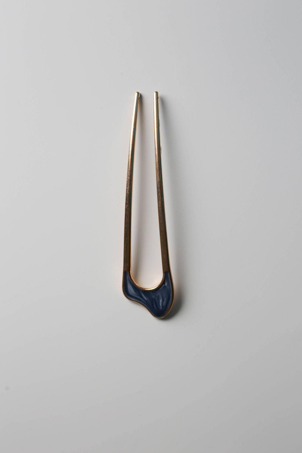 Vintage-inspired gold hair accessory with blue inlay.