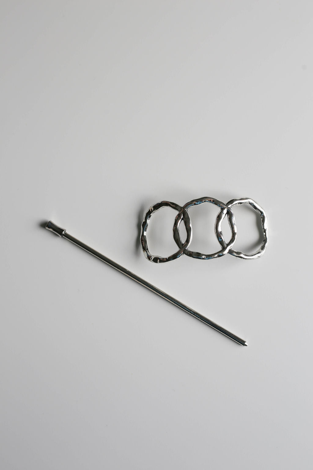Chic geometric silver pin for textured or long hair.
