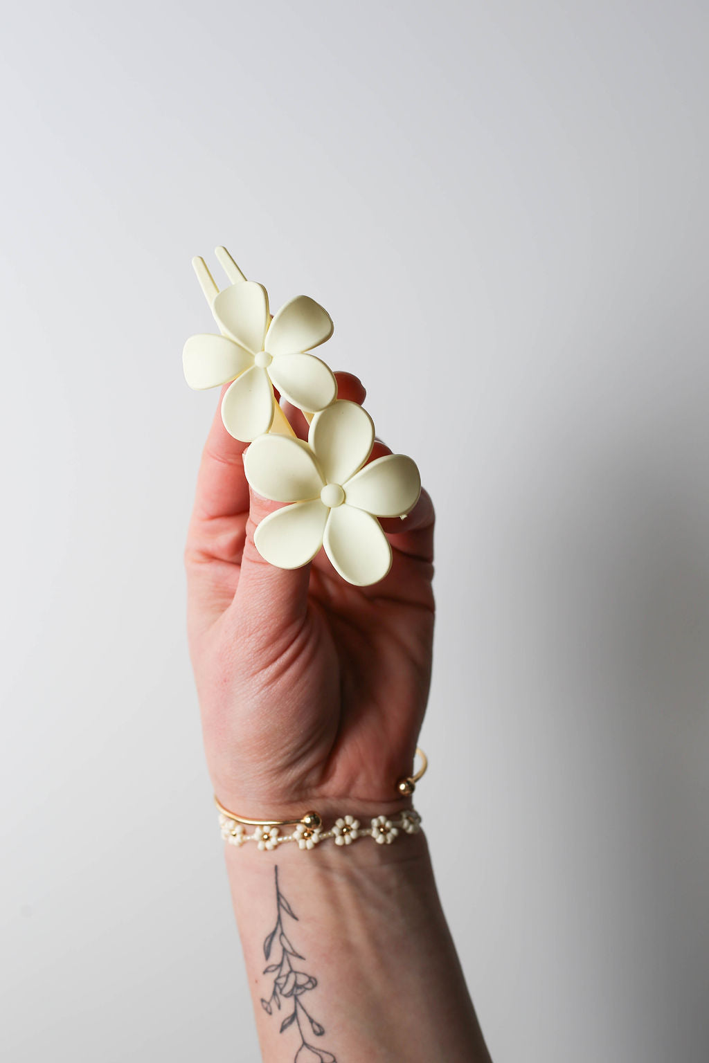 Neutral cream travel-safe flower clip with flat base for all-day wear