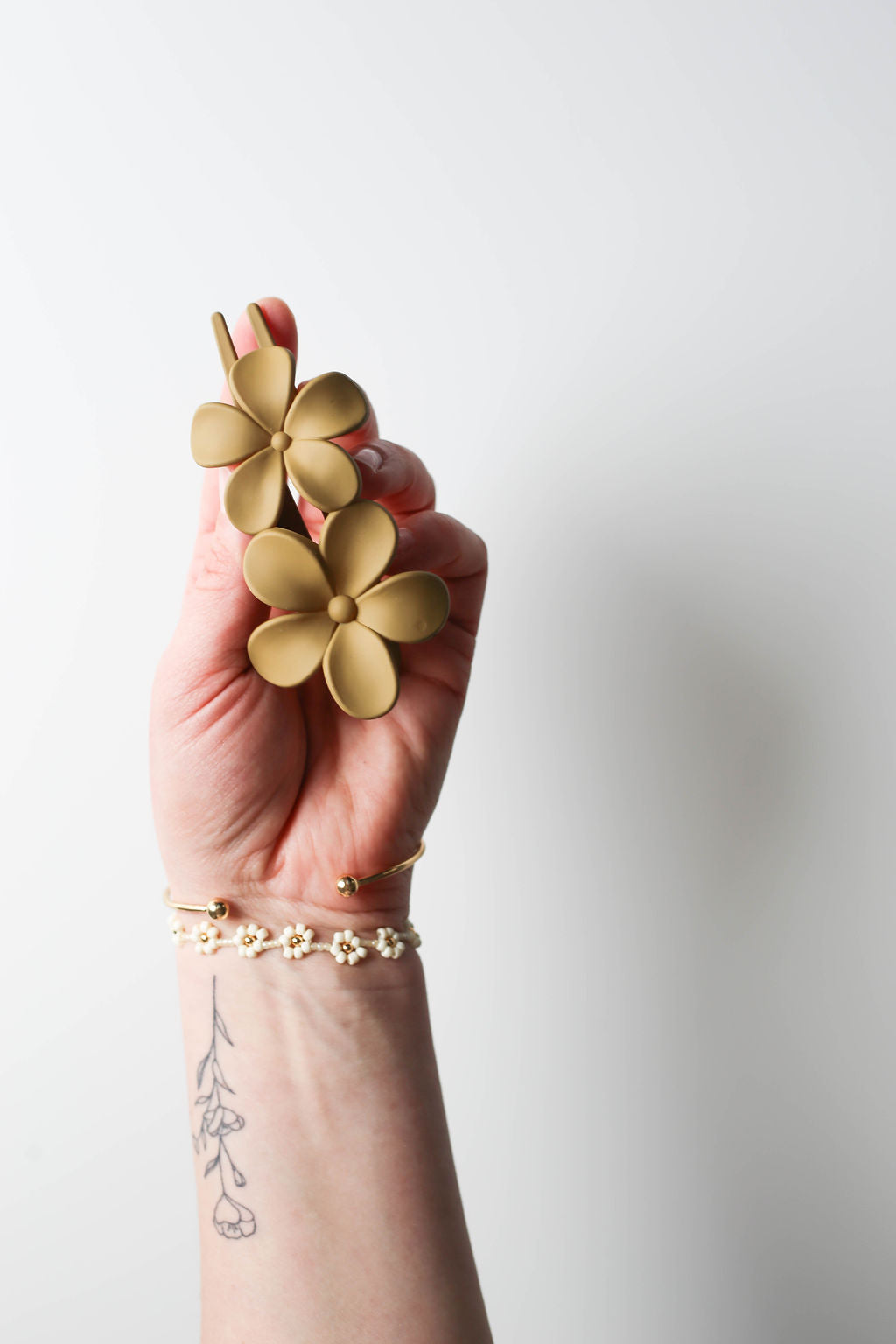 Sandy yellow travel-friendly flower claw clip with a low-profile shape