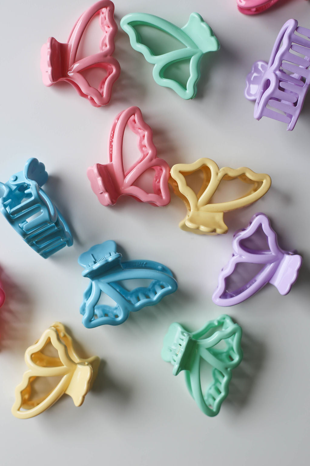 A colorful collection of 1.5-inch pastel hair clips styled in a delicate butterfly shape.