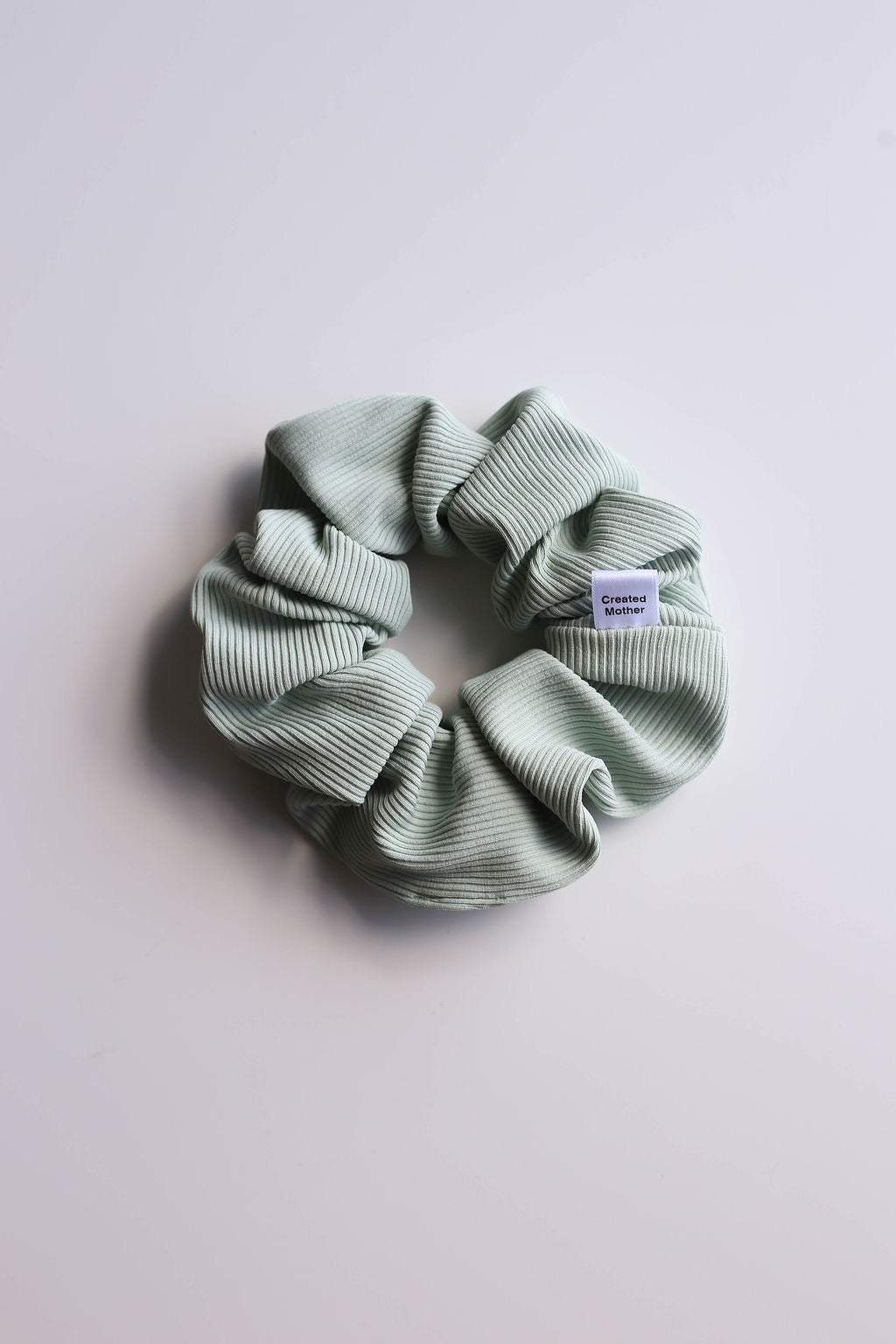 Light sage SWIM scrunchie with a chic ribbed design for all hair types.