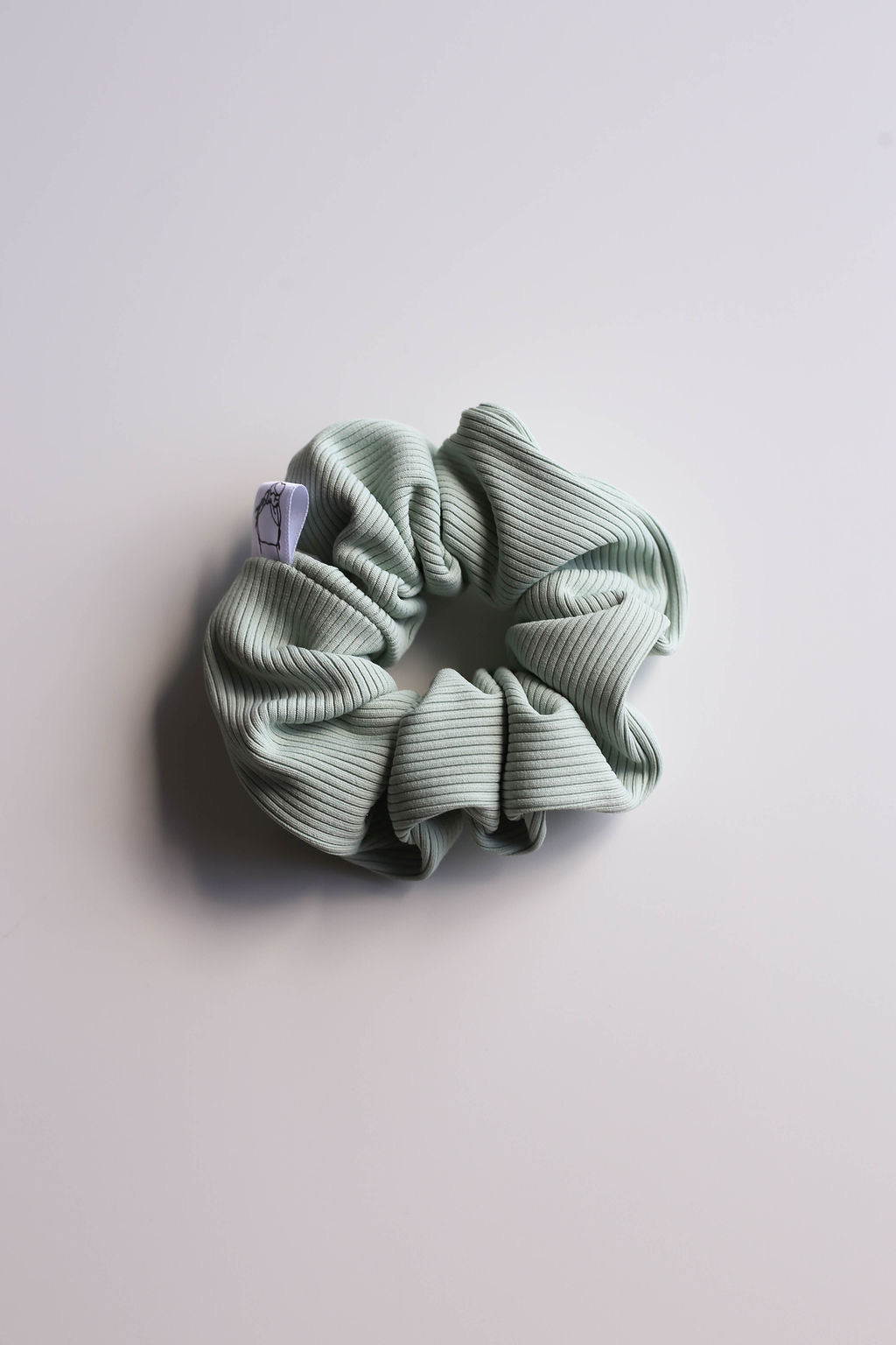 Light sage scrunchie crafted with premium swimsuit material for durability.
