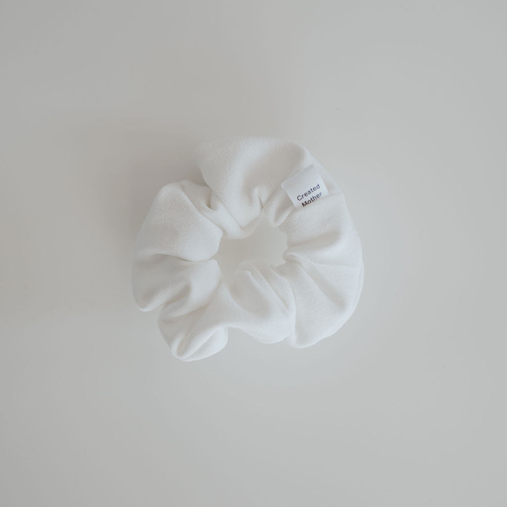 White scrunchie on a light gray background