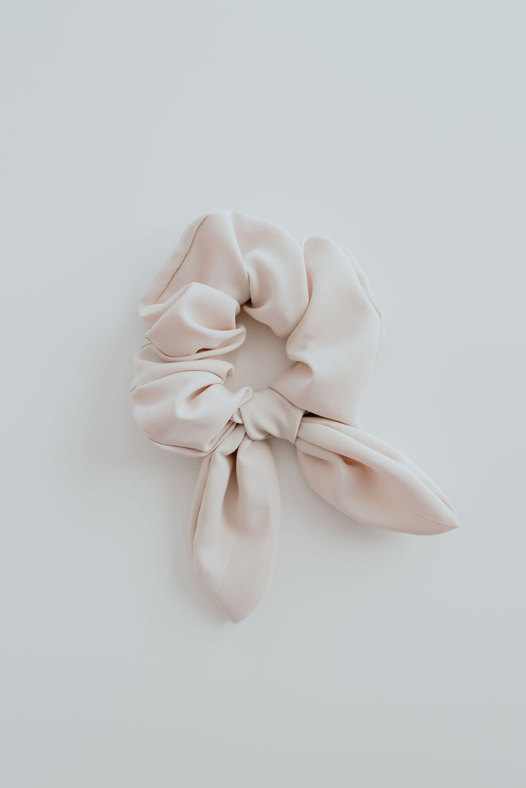 Beige scrunchie on a light gray background