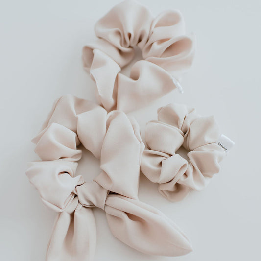 Set of beige scrunchies on a light gray background