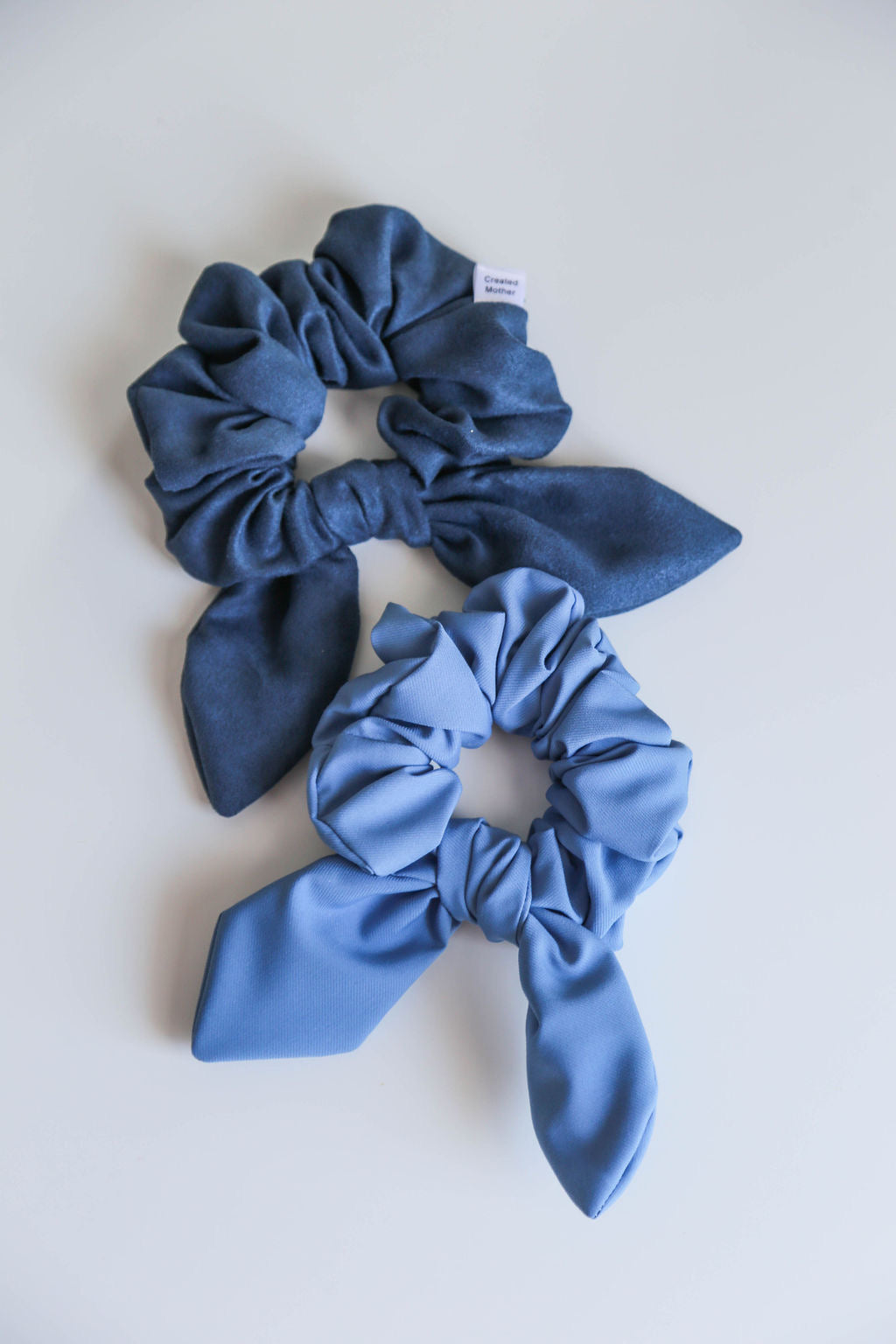 A medium-weight blue scrunchie with delicate texture, locally handmade for versatile styling.