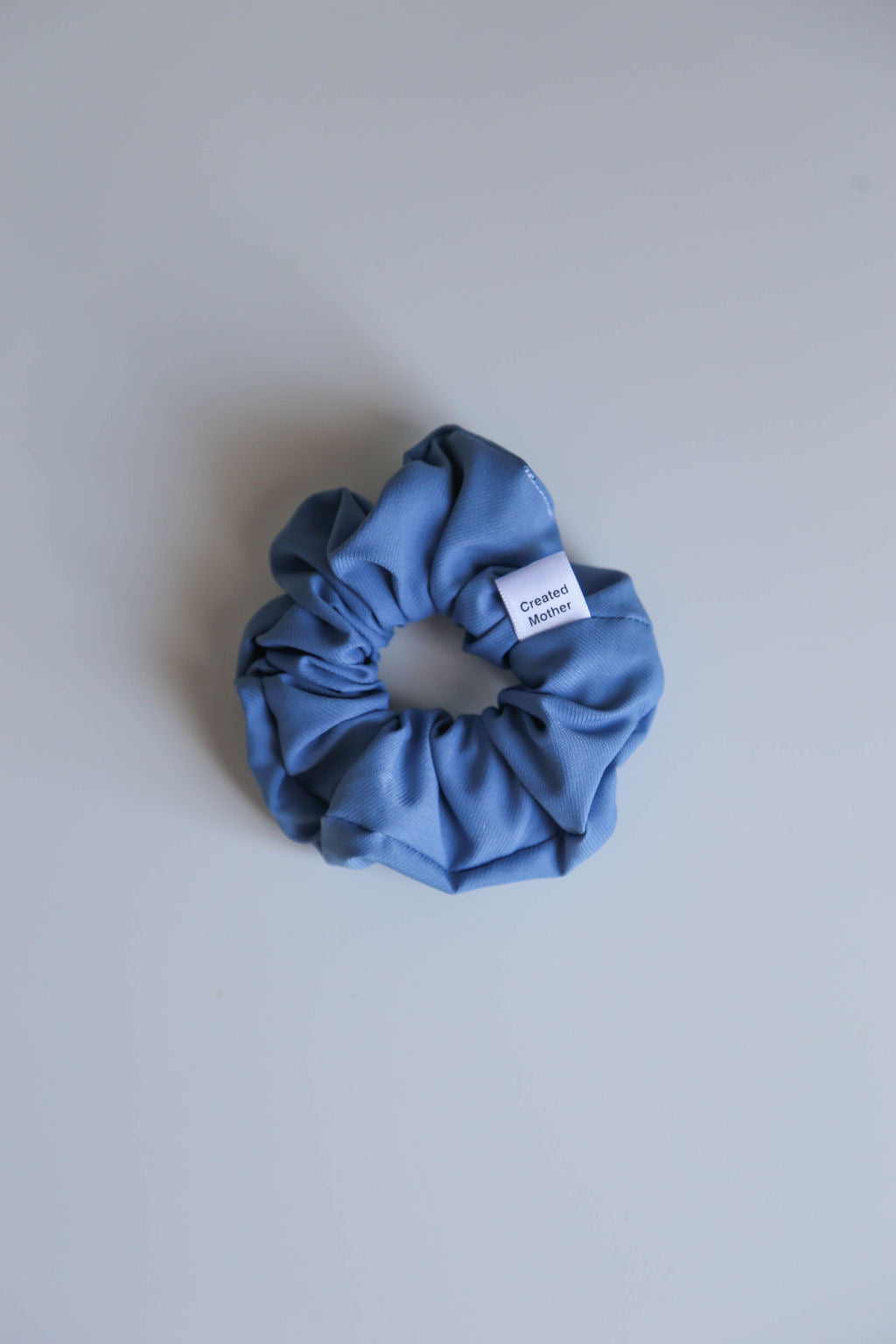 A sophisticated blue scrunchie featuring subtle texture and secure all-day hold elastic.