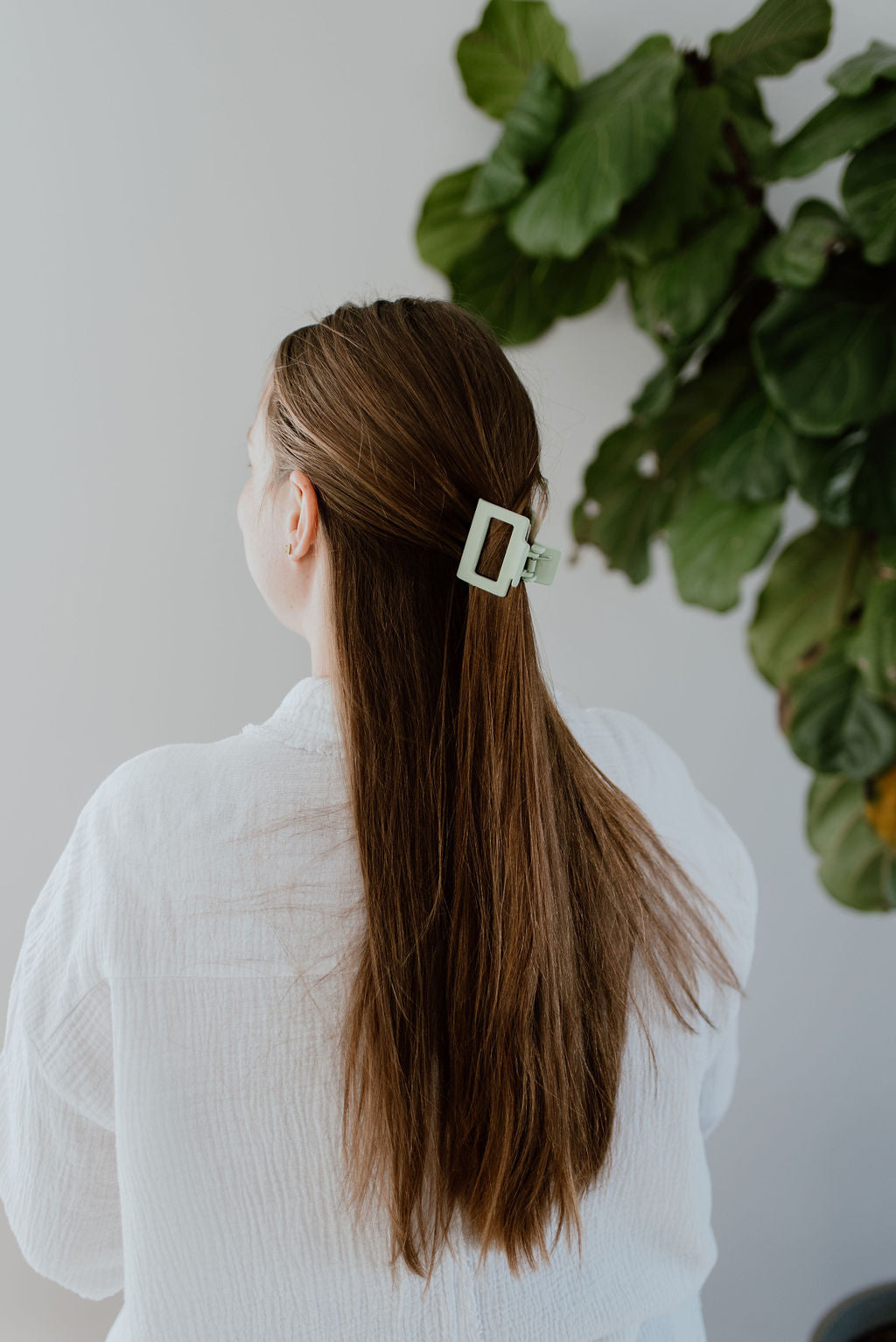 Effortless and chic half-up hairstyle created with a small modern square hair clip.