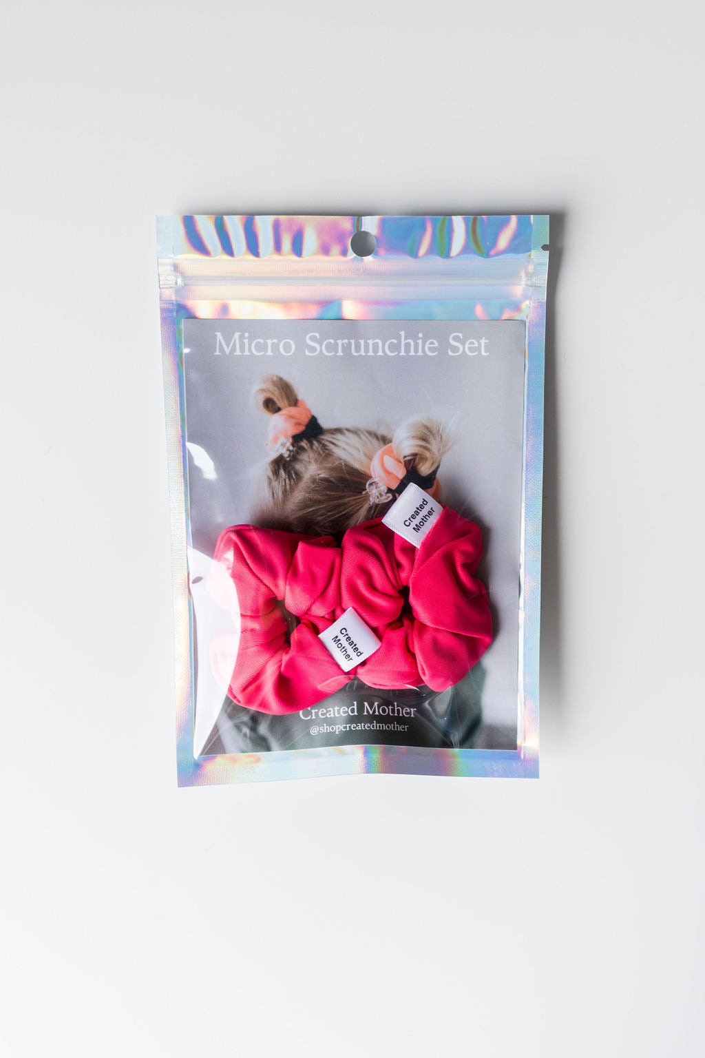 Package of micro scrunchie set with two Pink SWIM  scrunchies on a light gray background