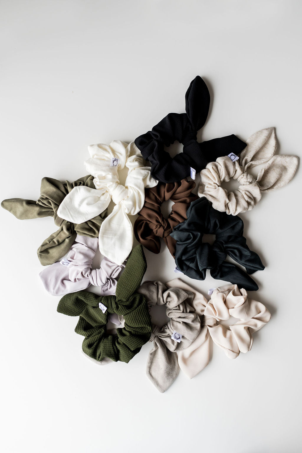 Collection of various colored scrunchies on a light gray background