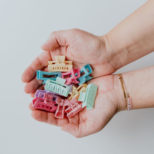 Assortment of pastel micro hair claw clips in soft shades of pink, blue, and green