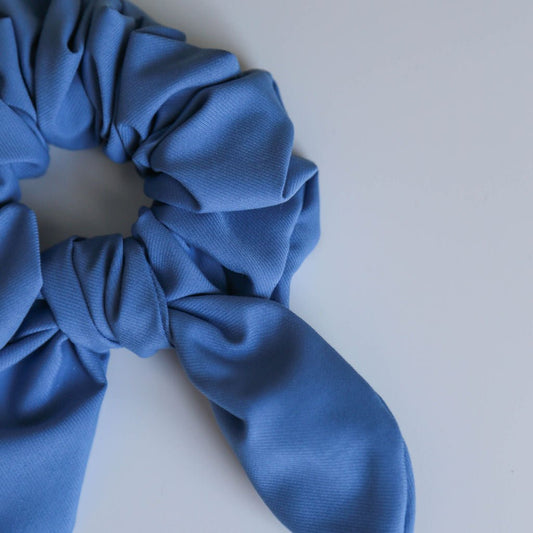 A textured blue scrunchie with a subtle design, handmade for versatile all-day wear.