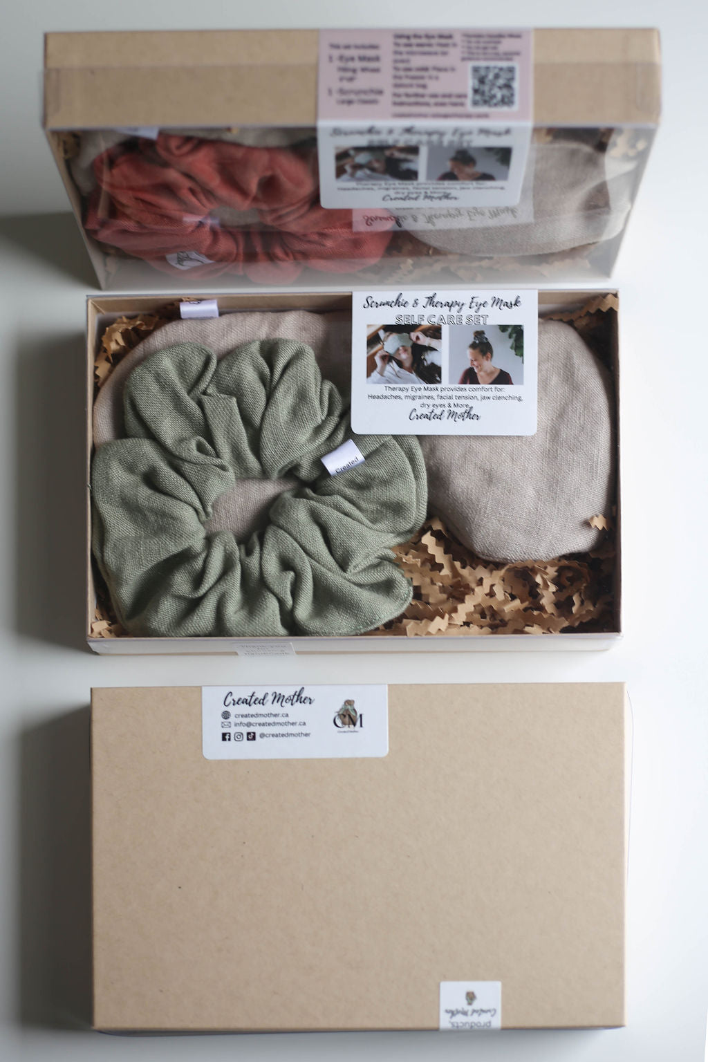 Self-care gift set open to reveal linen eye mask and hair scrunchie on crinkled tissue paper.