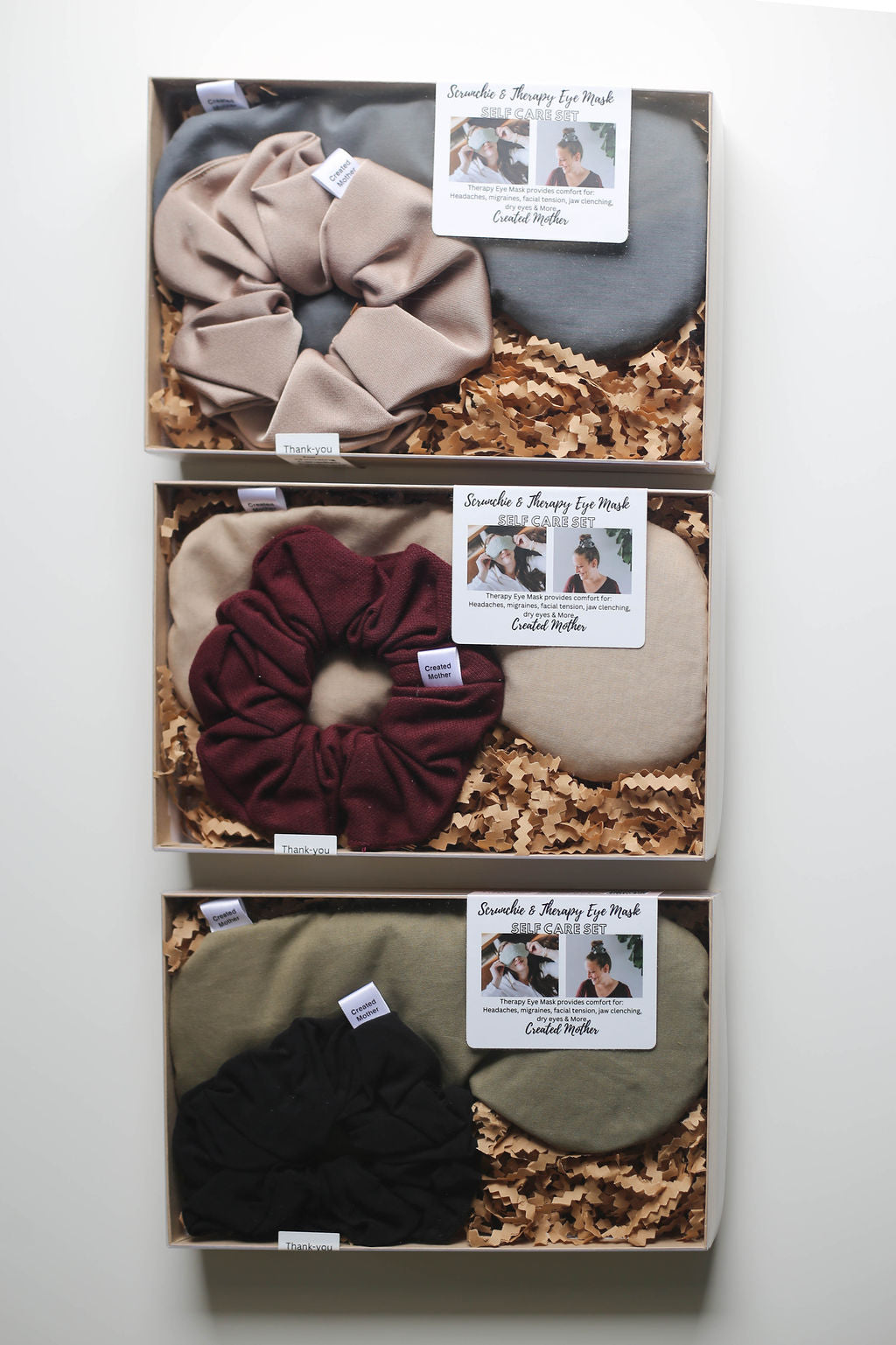 Neutral-toned eye mask and scrunchie set displayed in a kraft gift box with clear lid.