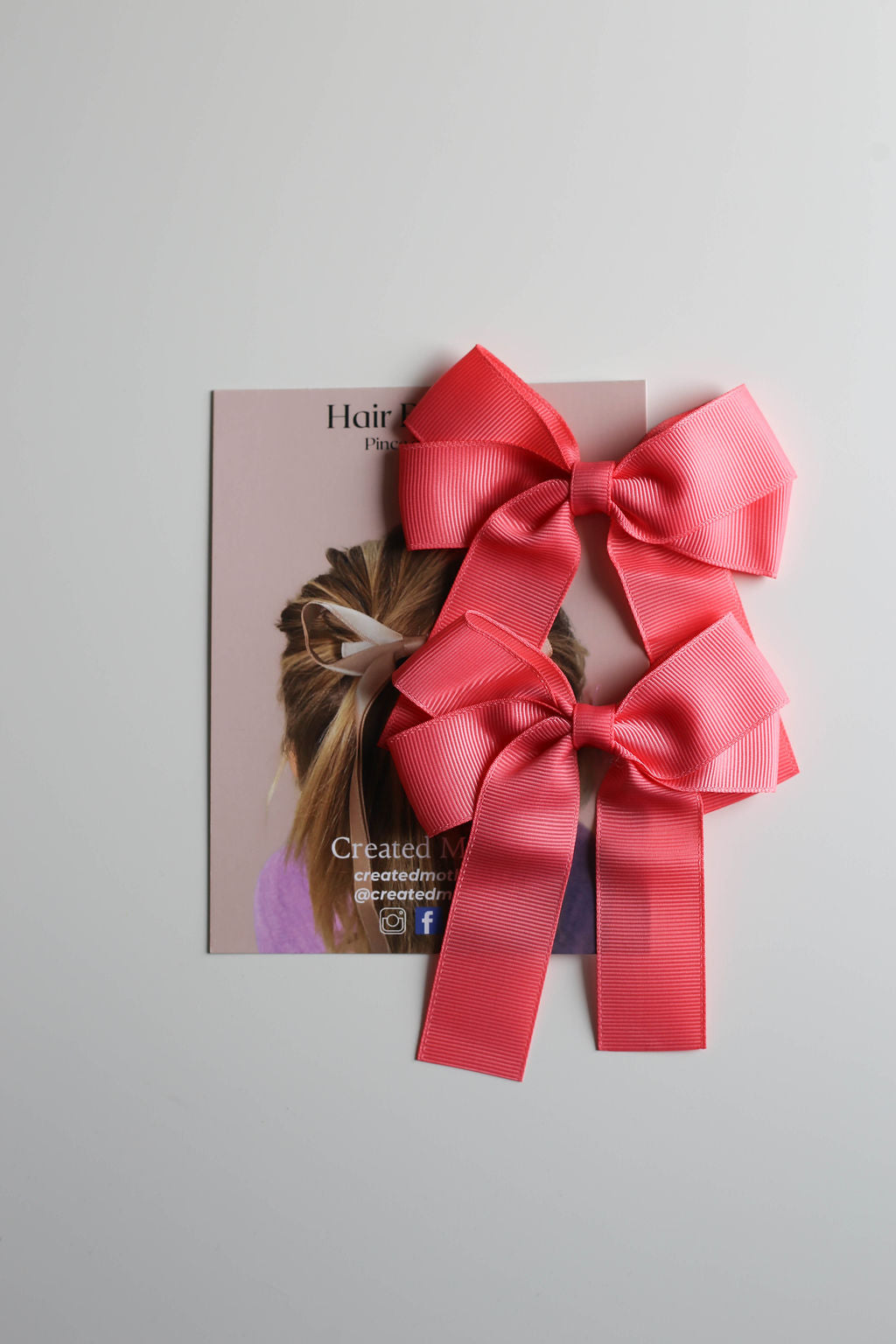 Oversized bow clip in coral, styled for casual or formal hair looks.