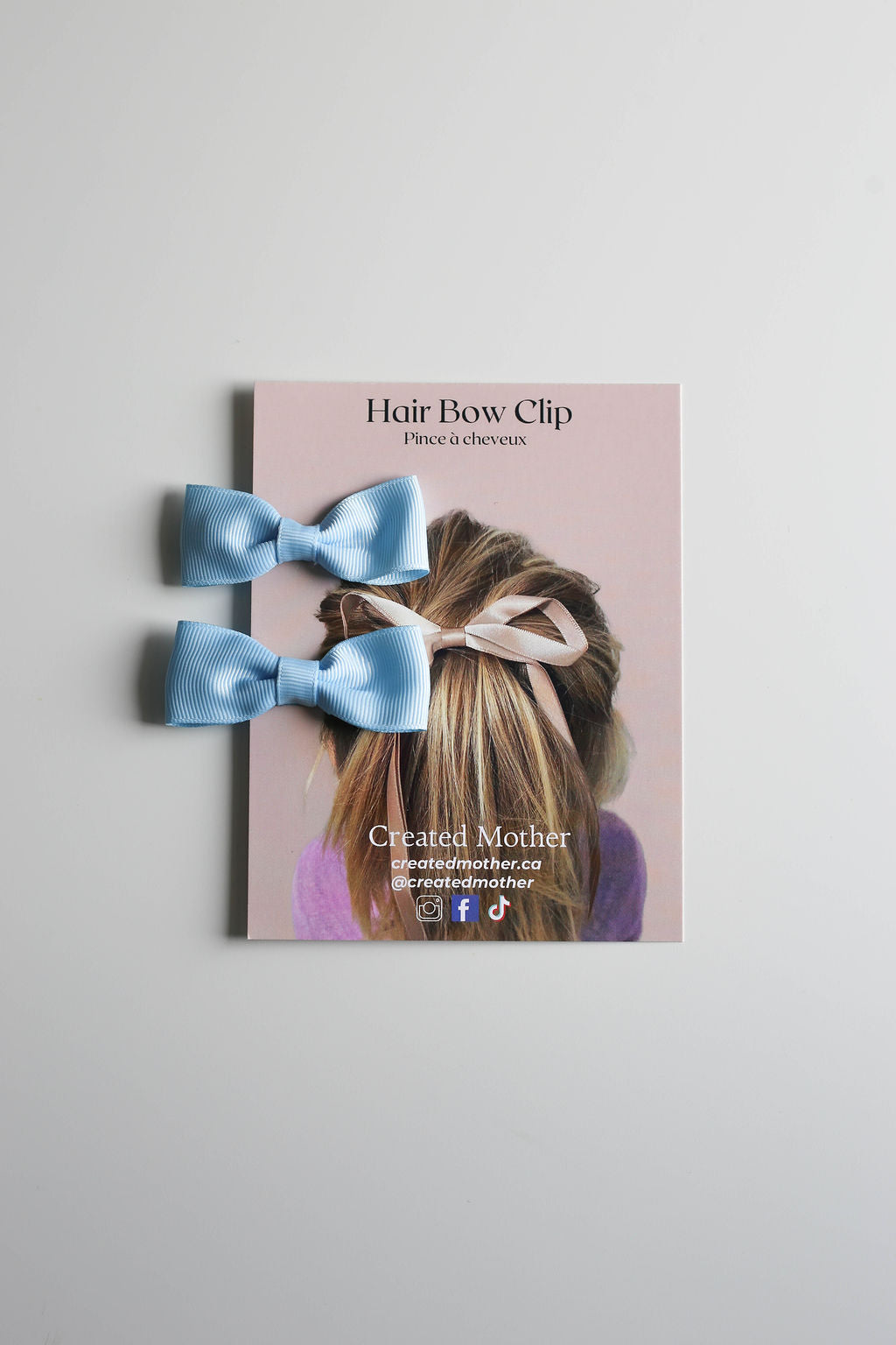 Bright light blue bow clip pair, designed to add charm to any hairstyle.