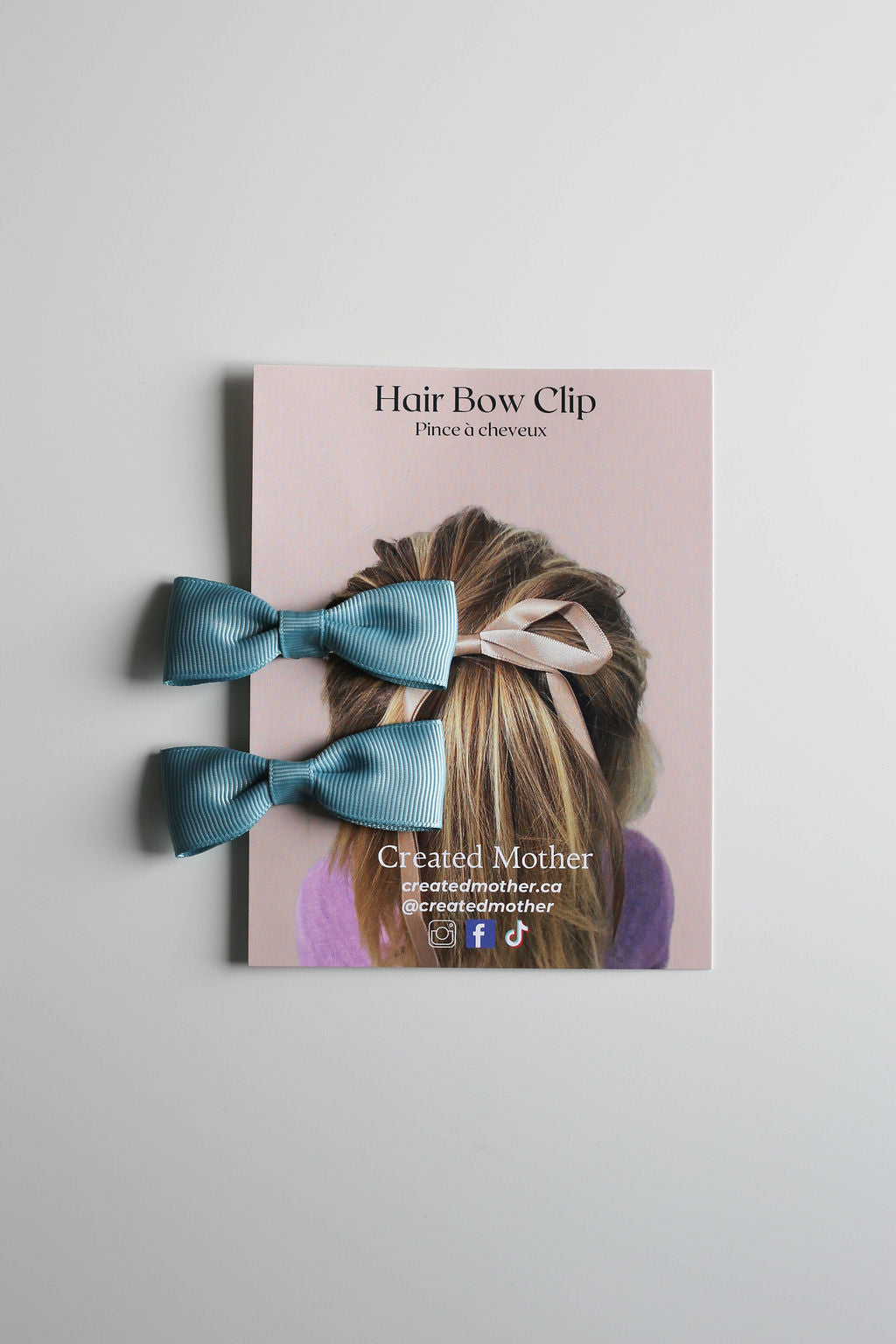 Display card featuring two handcrafted bow clips in a trendy teal.