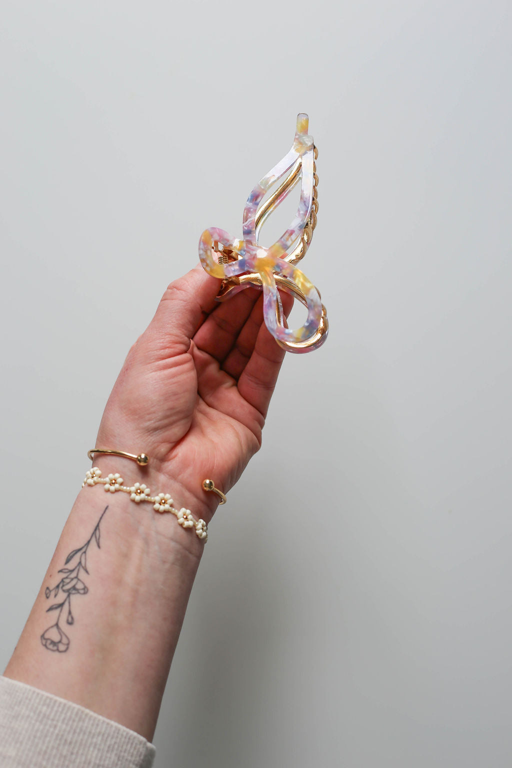 Whimsical and feminine purple bow claw clip with rainbow acetate detailing.