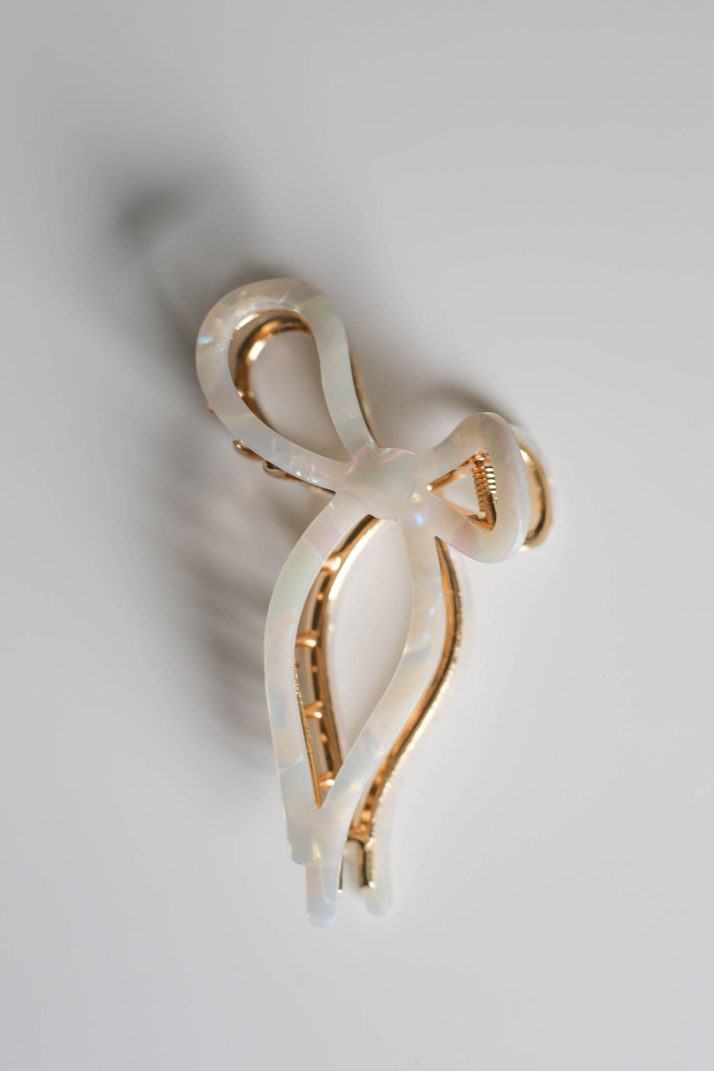 Elegant large bow hair claw in pearly white acetate, perfect for thick or long hair.
