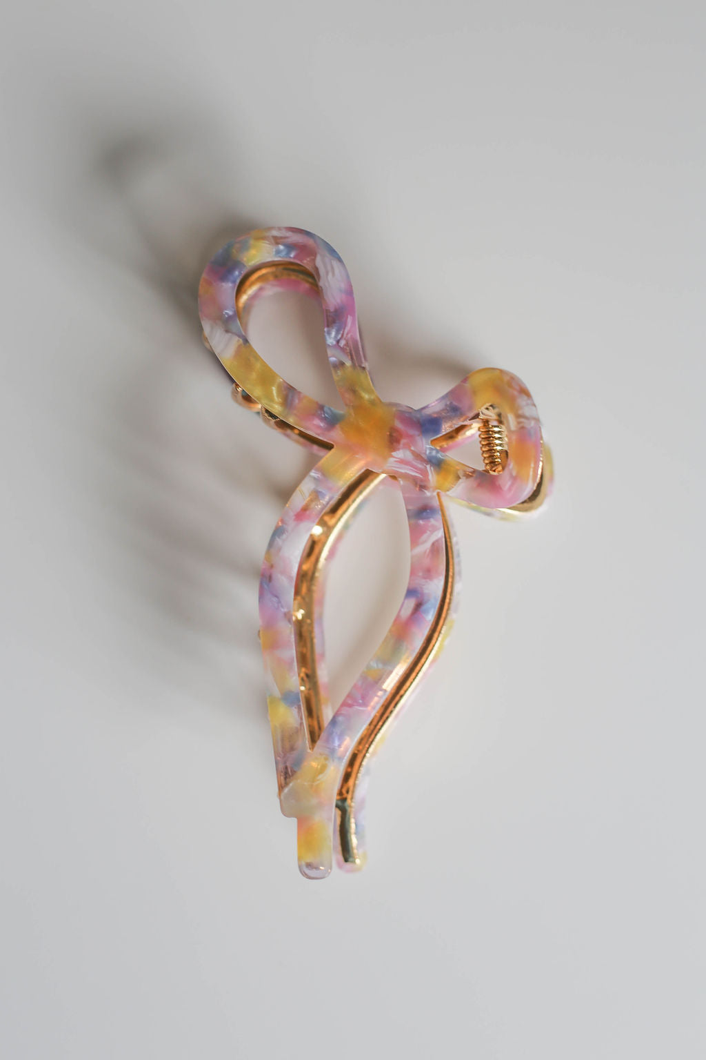 Vibrant multicolor acetate hair clip in a playful bow design with sturdy hold.