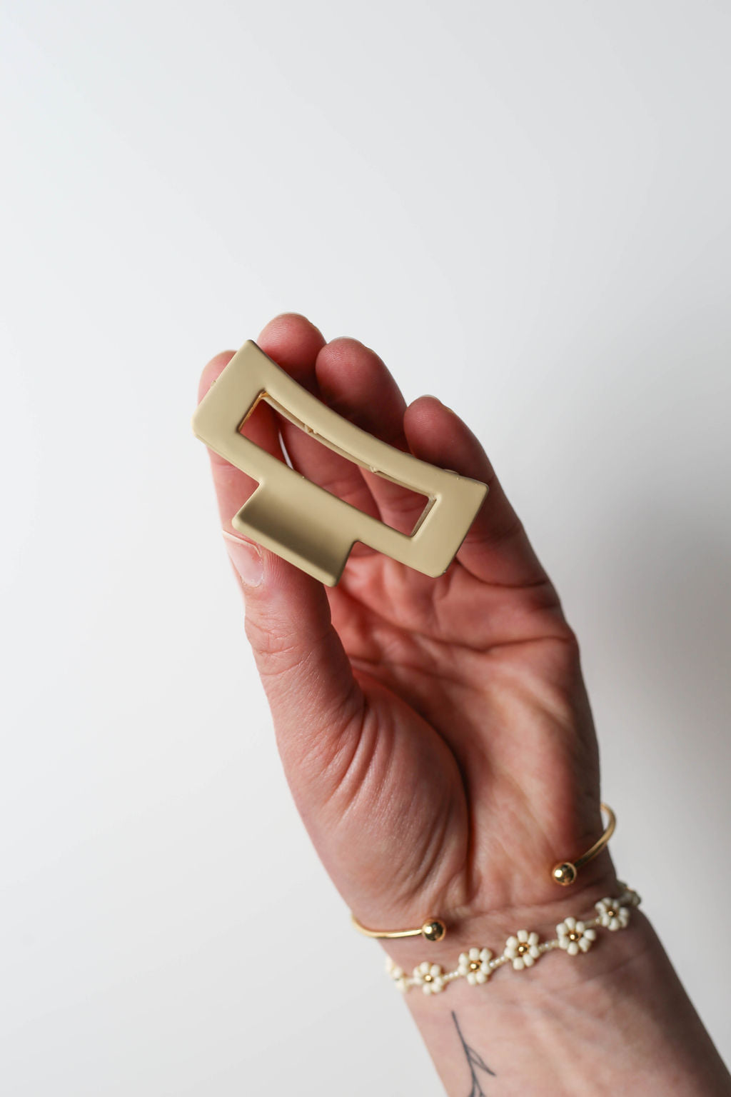 Close-up of a small matte claw clip showcasing curved teeth and strong grip spring.