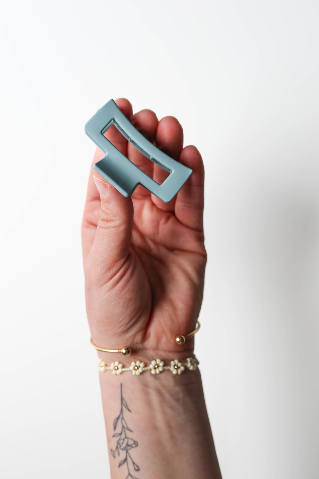 Compact blue hair claw clip designed with a bold matte finish and minimalist curve.