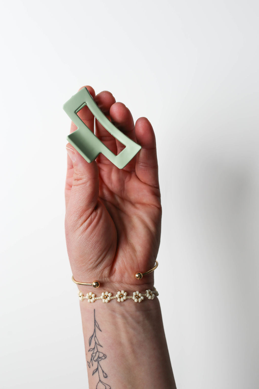 Small light green claw clip with soft edges, adding a playful pop of colour to your look.