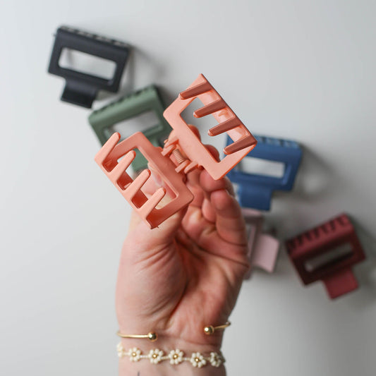 colorful 2” square claw clips displayed on a neutral background, showcasing assorted styles.