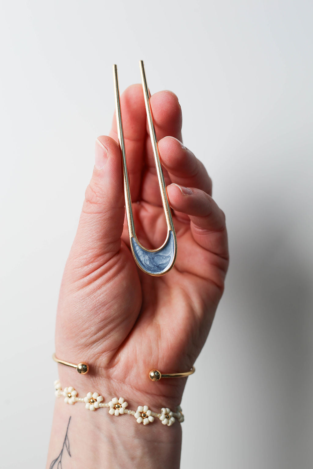 Gold hair pin for textured hair, with blue enamel finish.