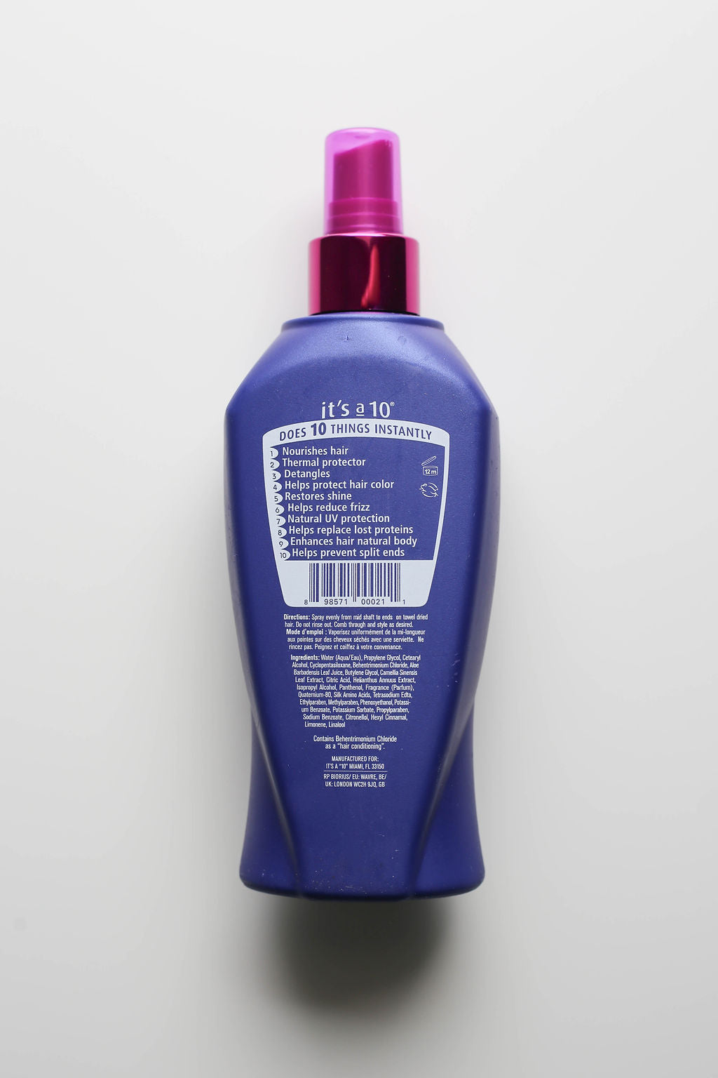 Blue bottle with purple cap on a light gray background