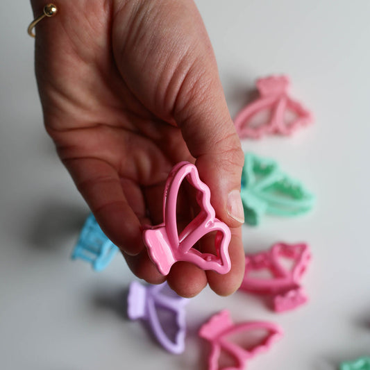 Assorted pastel butterfly-shaped micro hair claw clips designed for fine hair and small sections.