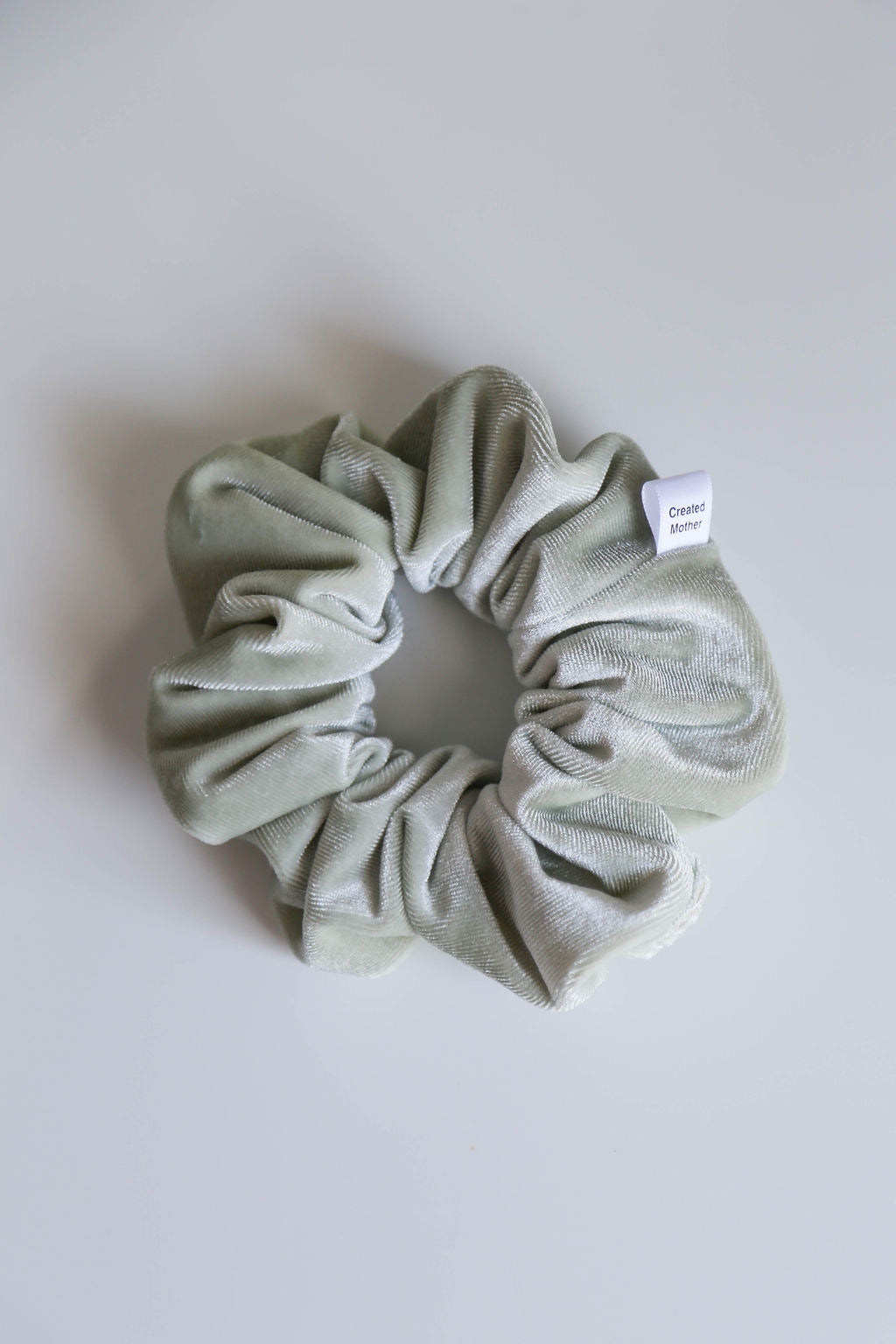 Luxurious sage green velvet scrunchie featuring gentle all-day hold and sophisticated style.