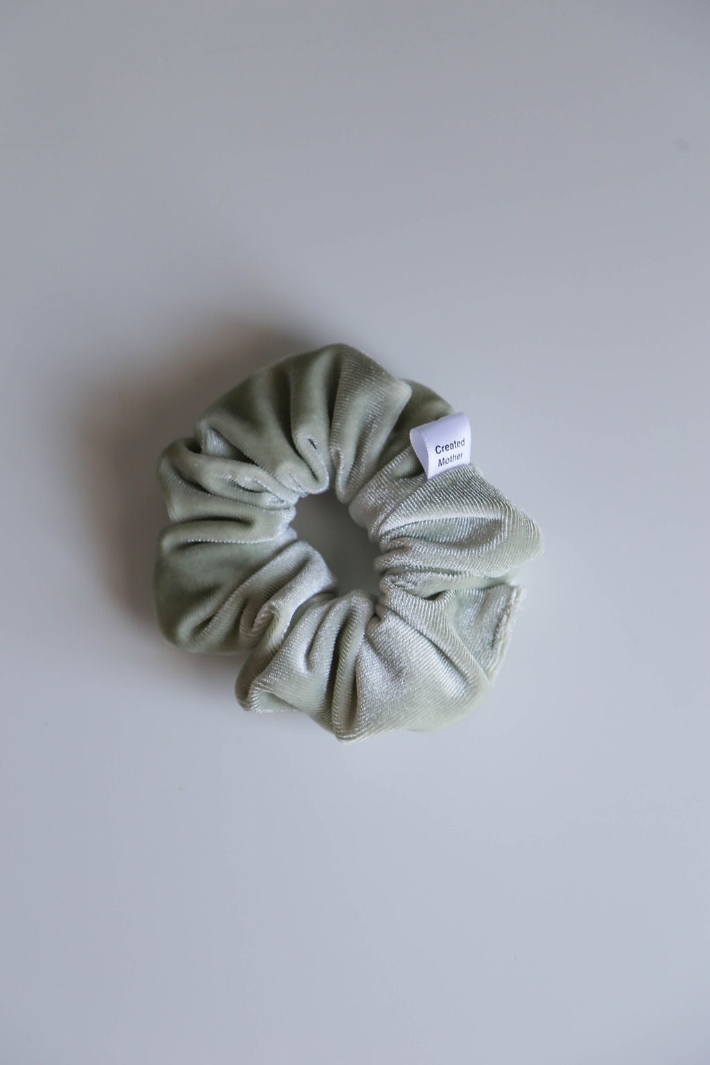 Handcrafted sage green velvet scrunchie with soft, premium texture, perfect for versatile styling.