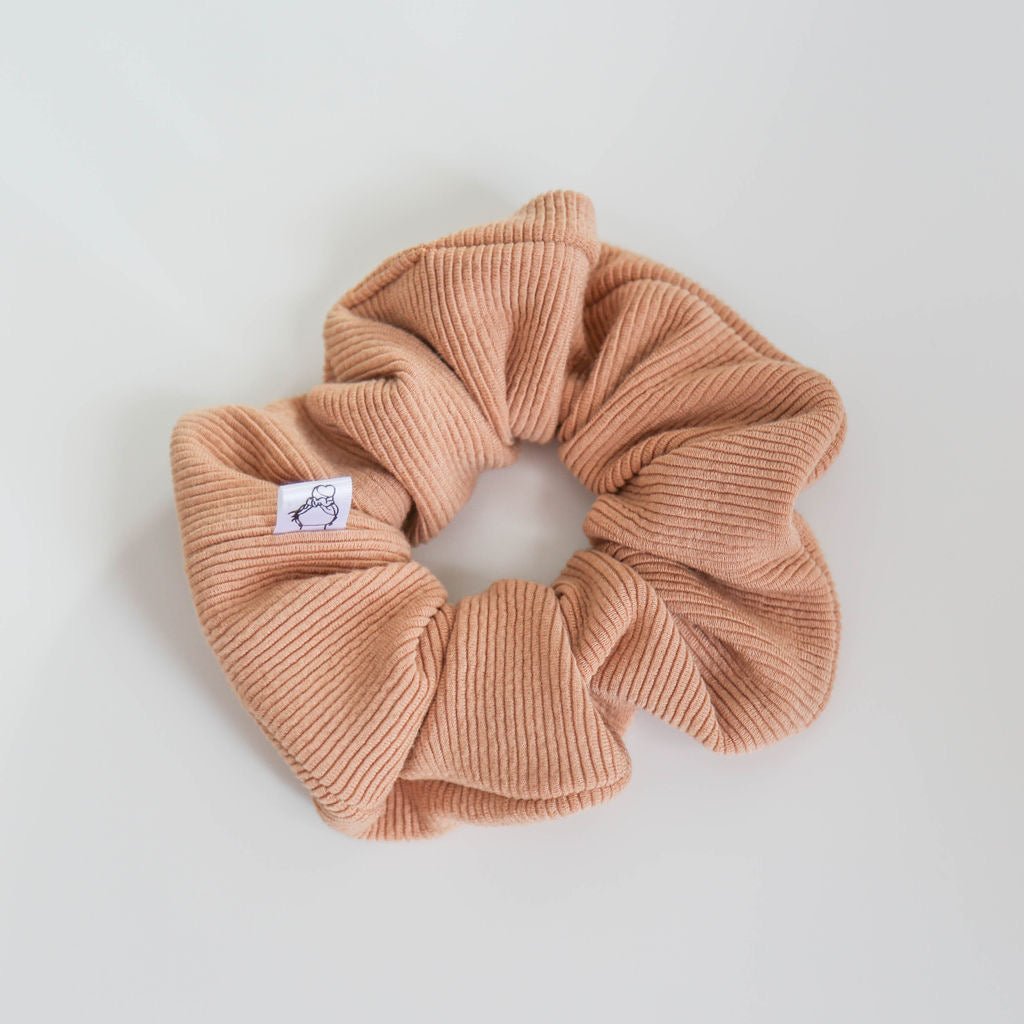 A cozy, neutral-toned thick ribbed scrunchie with a textured knit design, handmade for all-day hold.